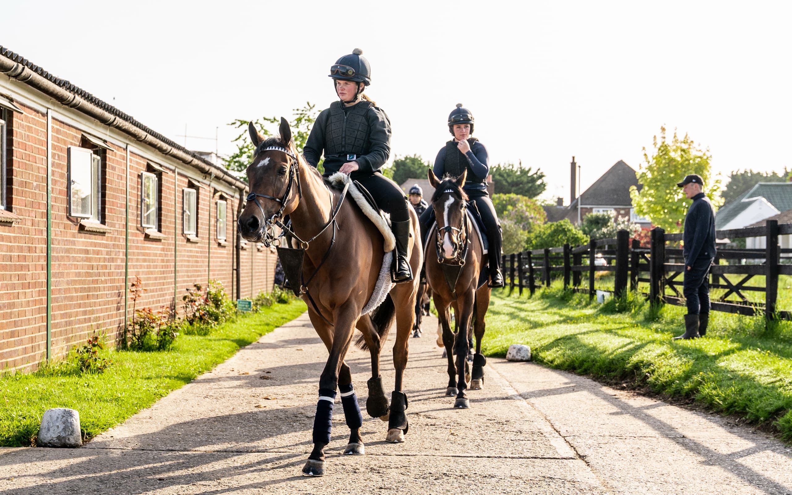 Riders walking horses past the boxes at Craven House Stables