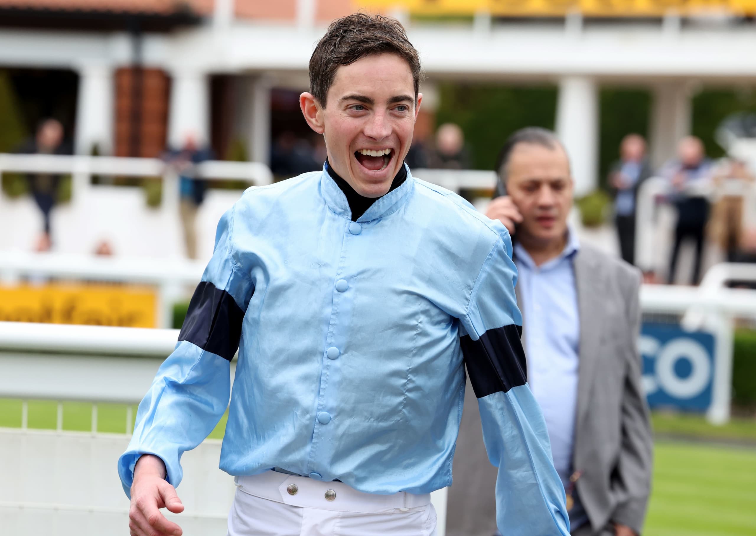 Jockey in light blue silks smiling after the race
