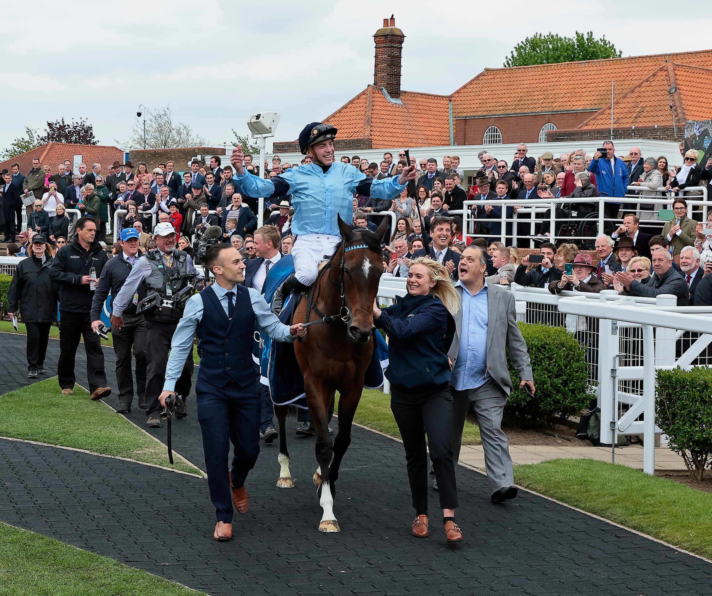 Jockey celebrating as the winner is led in through the crowd
